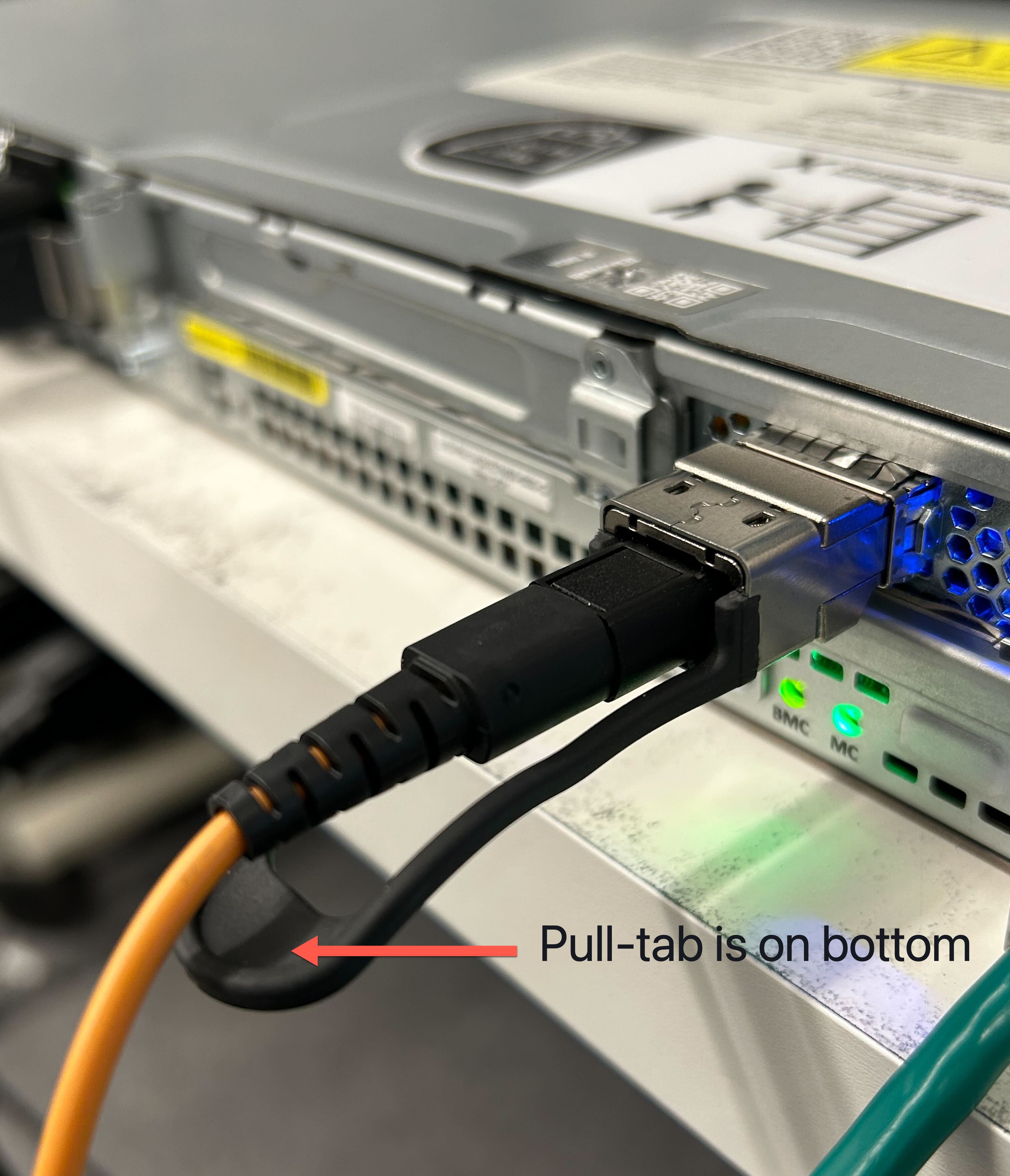 
                    Câble QSFP branché sur un serveur 1U avec la languette en dessous.
                  