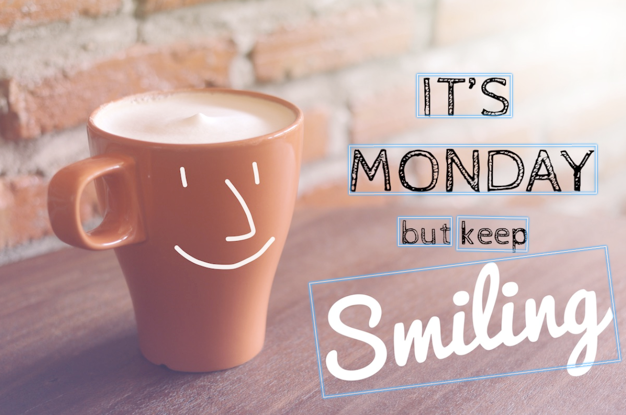 Mug kopi tersenyum di sebelah teks yang bertuliskan “Ini hari Senin tapi tetap Tersenyum” dengan latar belakang batu bata, dengan kotak pembatas teks.