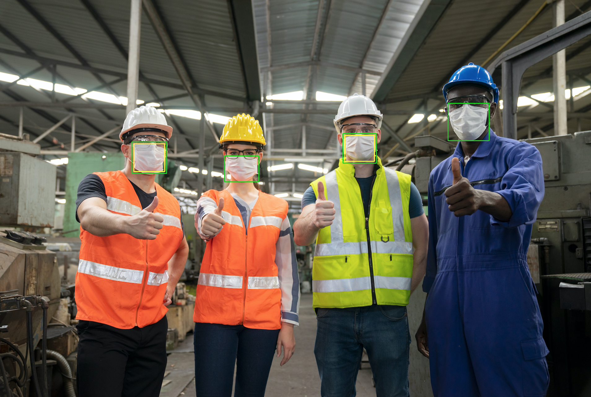 Empat pekerja di sebuah gudang, mengenakan rompi visibilitas tinggi, helm, kacamata keselamatan, dan masker. Topeng dikelilingi oleh kotak pembatas.