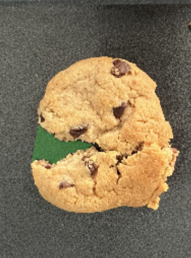 Chocolate chip cookie broken in half, revealing a green filling inside.
