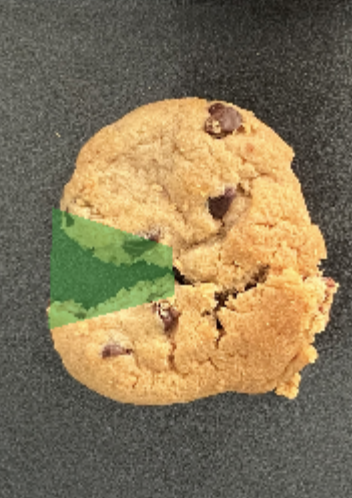 Chocolate chip cookie with a bite taken out, revealing green filling inside.