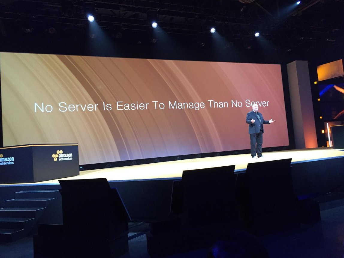 Image of Werner Vogels on stage in front of a banner.