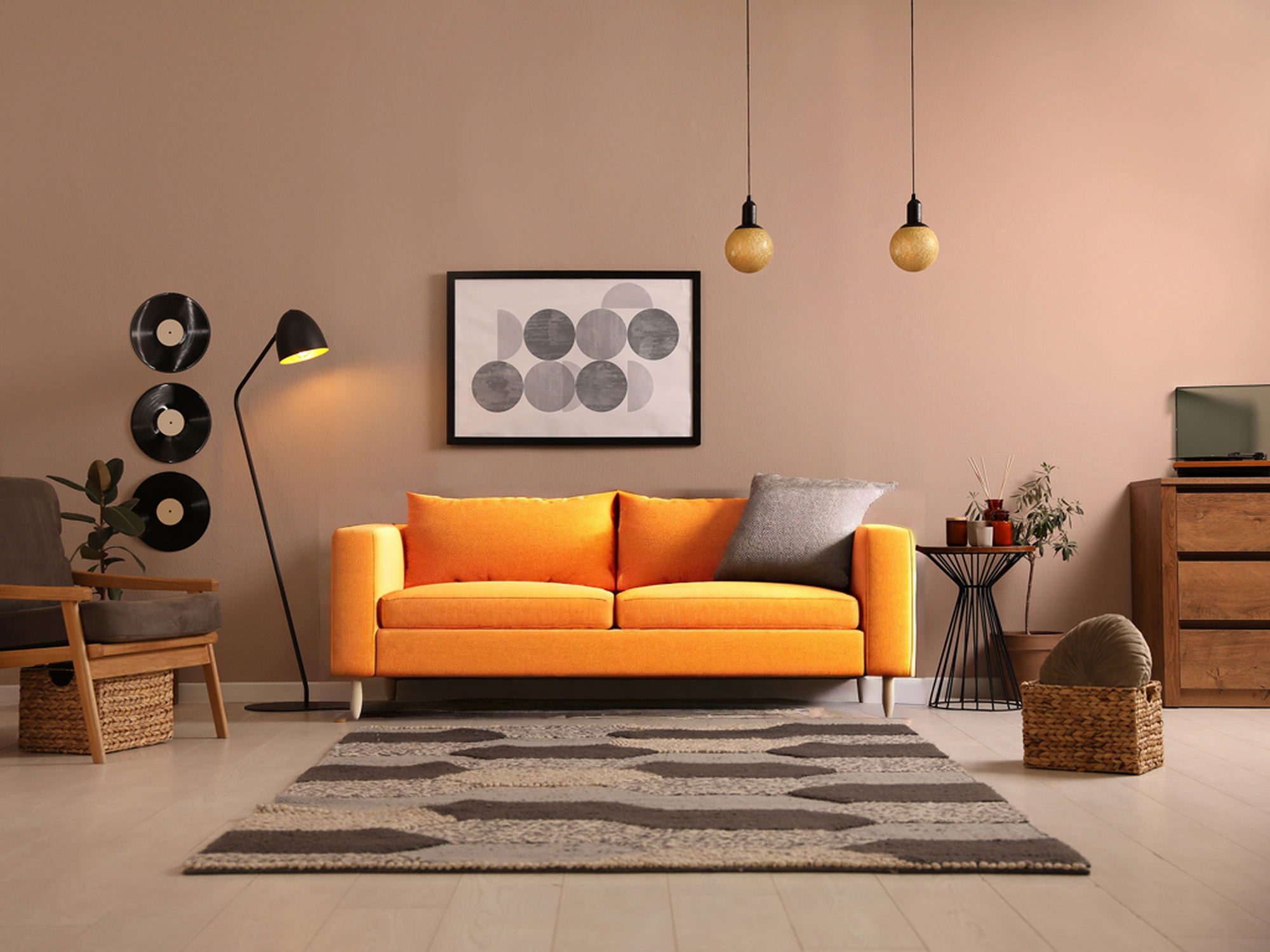 Un divano arancione in una stanza circondata da altre decorazioni.
